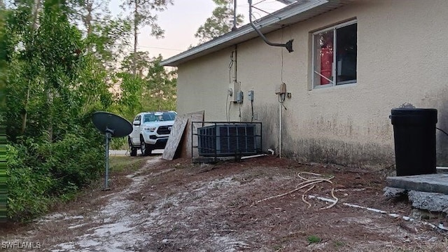 view of home's exterior with central air condition unit and stucco siding