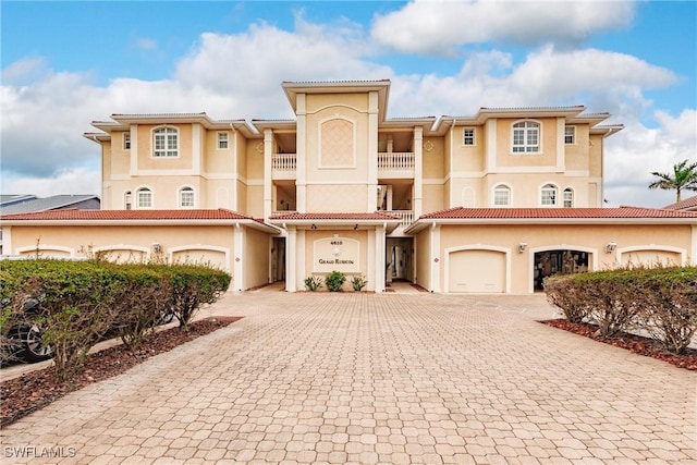 view of front of house with a balcony, decorative driveway, and stucco siding