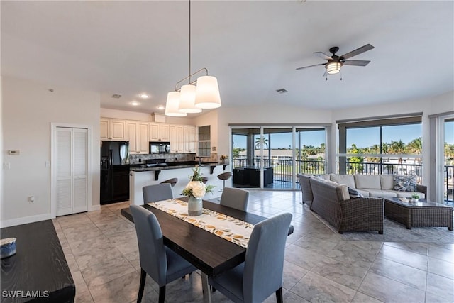 dining room featuring visible vents, baseboards, lofted ceiling, and a ceiling fan