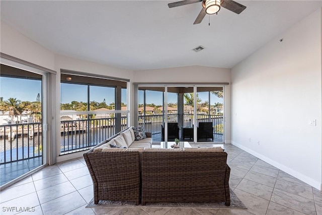 sunroom featuring lofted ceiling, a ceiling fan, and visible vents