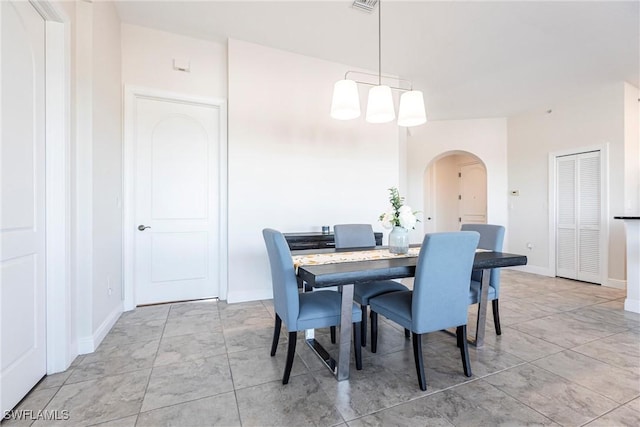 dining area with arched walkways and baseboards