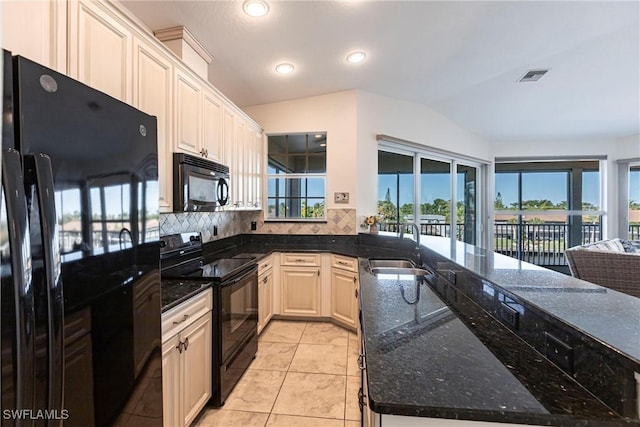 kitchen featuring visible vents, backsplash, a peninsula, black appliances, and a sink