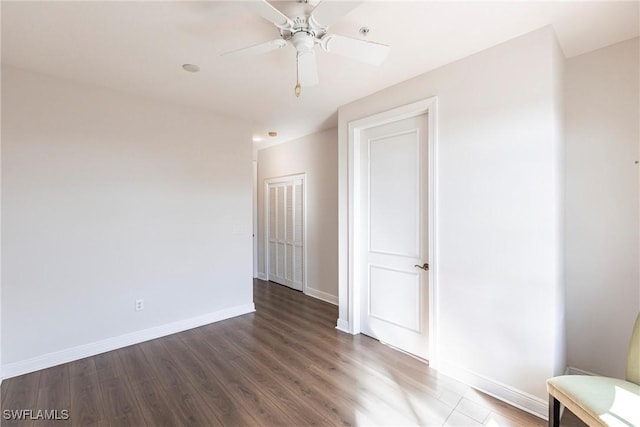 empty room featuring ceiling fan, baseboards, and wood finished floors