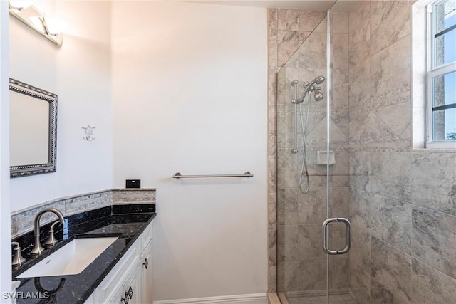 bathroom featuring a shower stall, vanity, and baseboards