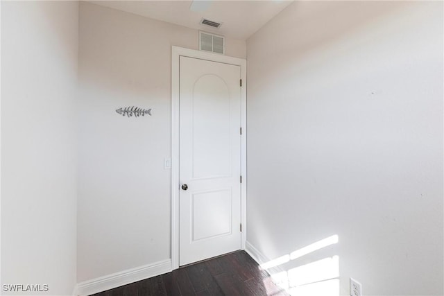 empty room with visible vents, baseboards, and dark wood-type flooring