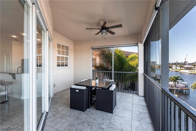 balcony featuring a ceiling fan and a water view