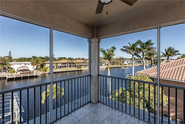 unfurnished sunroom with a ceiling fan and a water view