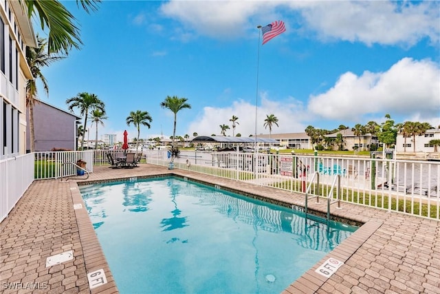 pool featuring a residential view, a patio, and fence