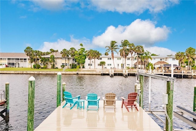 view of dock with a residential view and a water view