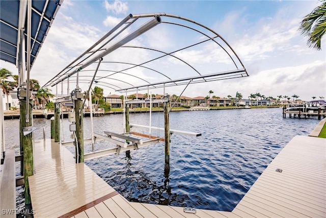 dock area with boat lift and a water view