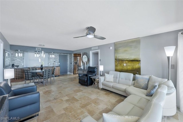 living room featuring stone finish floor and ceiling fan