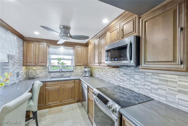 kitchen featuring a ceiling fan, a sink, tasteful backsplash, appliances with stainless steel finishes, and light countertops