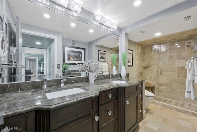 full bathroom featuring double vanity, a stall shower, visible vents, and a sink