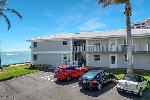 view of property with uncovered parking and a water view