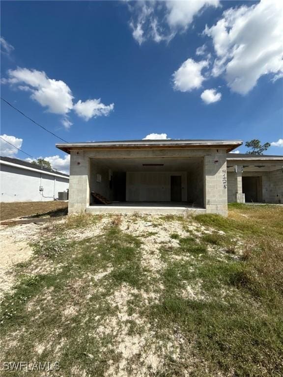 garage with an attached carport, central AC unit, and driveway