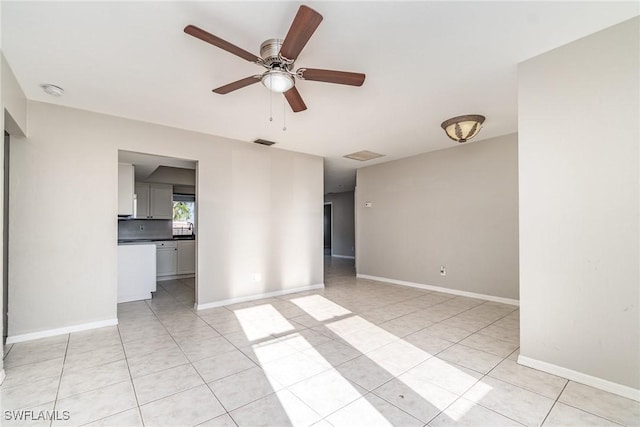 unfurnished room featuring light tile patterned floors, a ceiling fan, visible vents, and baseboards