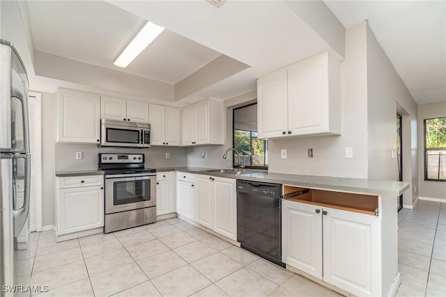 kitchen featuring a sink, appliances with stainless steel finishes, white cabinets, and a healthy amount of sunlight