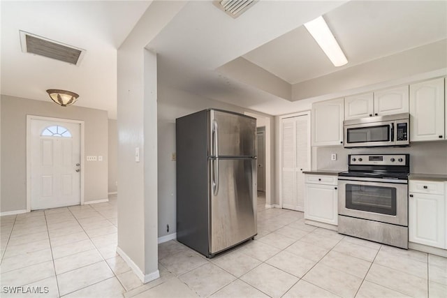 kitchen featuring light tile patterned floors, visible vents, appliances with stainless steel finishes, and white cabinetry