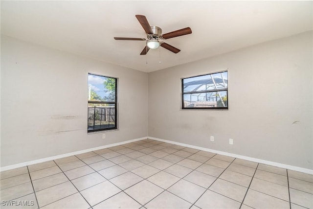 empty room with baseboards, a healthy amount of sunlight, and a ceiling fan