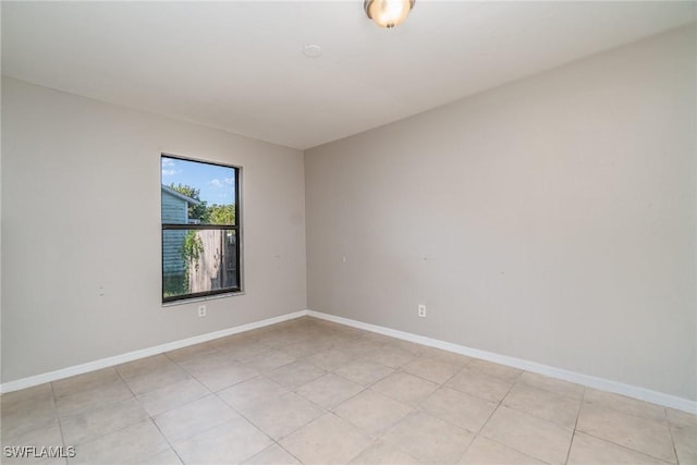 unfurnished room with light tile patterned floors and baseboards