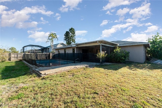 back of house featuring a fenced in pool, fence, a lawn, glass enclosure, and stucco siding