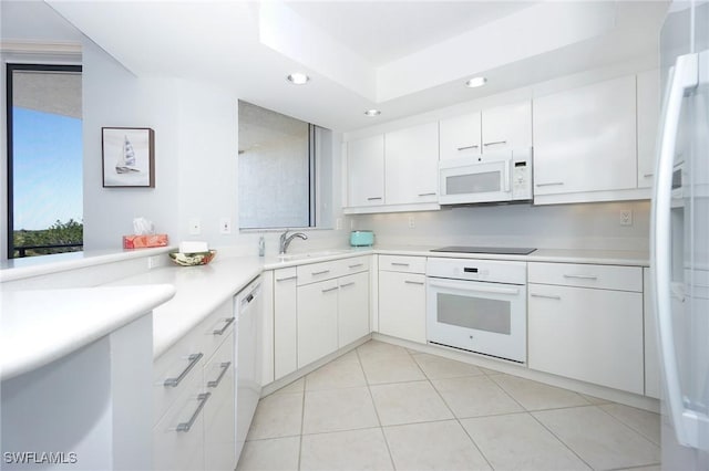 kitchen featuring light countertops, recessed lighting, white cabinets, white appliances, and a sink