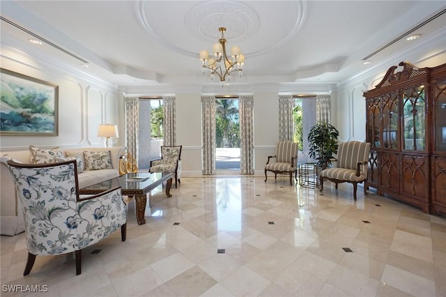 sitting room featuring a notable chandelier, crown molding, and a raised ceiling