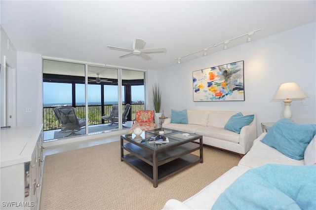 living area with ceiling fan, rail lighting, and expansive windows