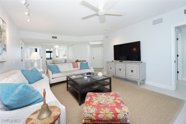 living room featuring light tile patterned flooring, visible vents, baseboards, and ceiling fan