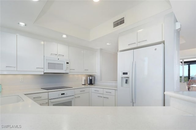 kitchen featuring a sink, visible vents, white appliances, and white cabinetry