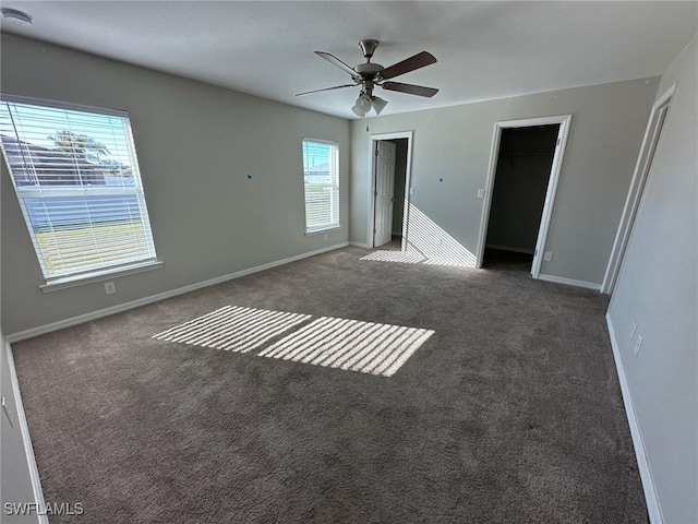 unfurnished bedroom with a ceiling fan, carpet, baseboards, and multiple closets