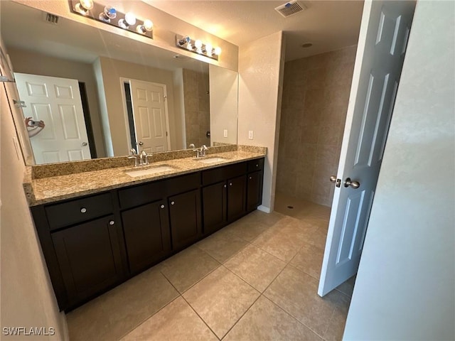 full bathroom featuring tile patterned floors, visible vents, double vanity, and a sink