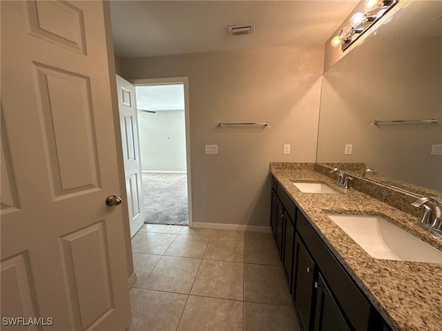 bathroom featuring tile patterned flooring, baseboards, visible vents, and a sink