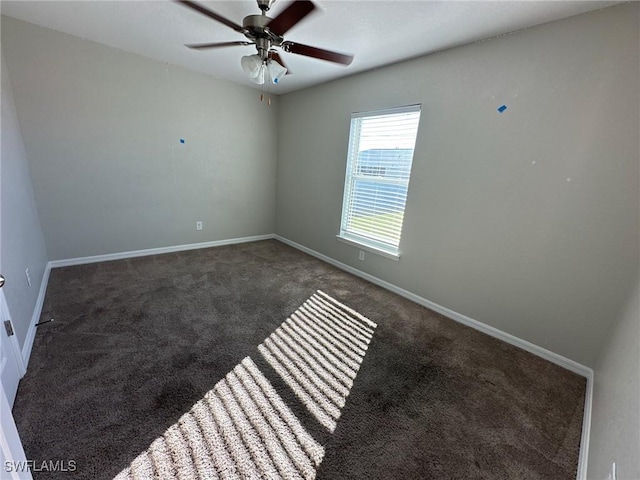 carpeted empty room with ceiling fan and baseboards