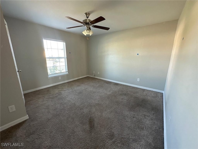 carpeted spare room with baseboards and ceiling fan