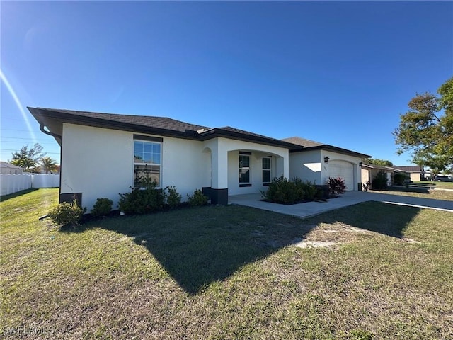 view of front of house featuring fence, driveway, an attached garage, stucco siding, and a front lawn