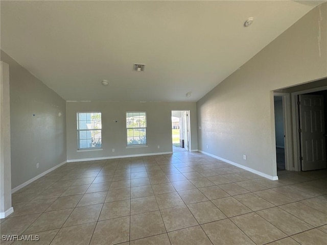 unfurnished room featuring light tile patterned floors, visible vents, baseboards, and vaulted ceiling