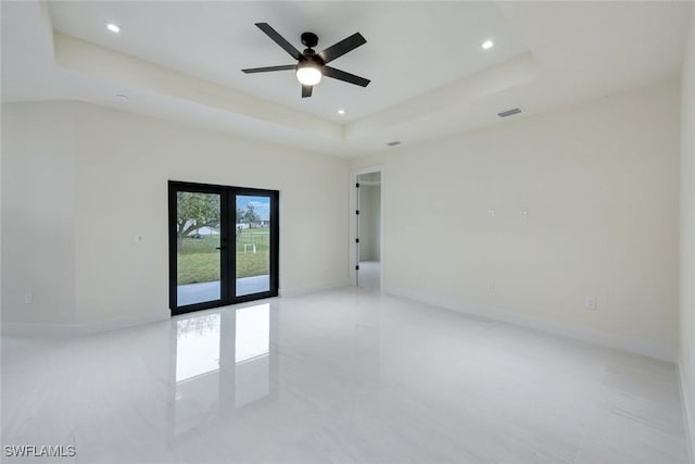 unfurnished room with recessed lighting, french doors, a raised ceiling, and baseboards