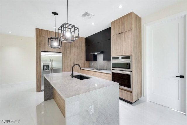 kitchen with visible vents, modern cabinets, a sink, decorative light fixtures, and appliances with stainless steel finishes