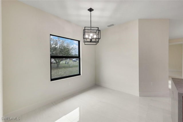 empty room featuring visible vents, baseboards, and a chandelier