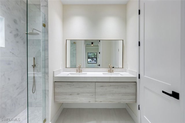 full bathroom with double vanity, a marble finish shower, and a sink