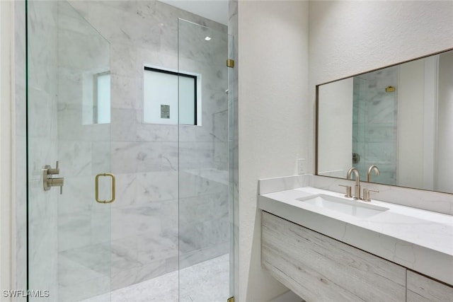 full bath featuring vanity and a marble finish shower