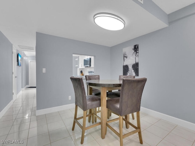 dining space with light tile patterned floors and baseboards