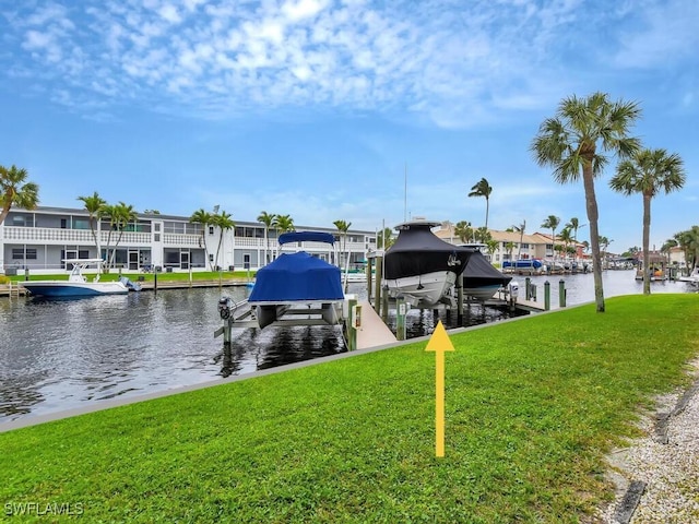 view of dock featuring boat lift, a residential view, a yard, and a water view