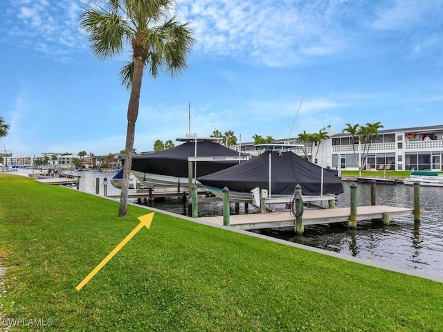 dock area with boat lift, a yard, and a water view