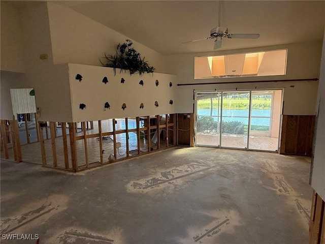 misc room with unfinished concrete floors and a towering ceiling