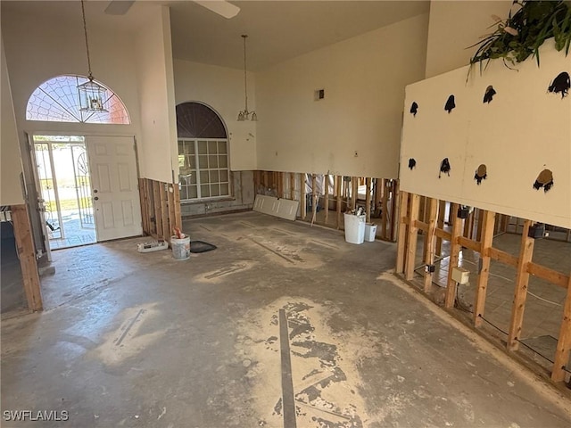 foyer featuring concrete flooring, visible vents, and a towering ceiling