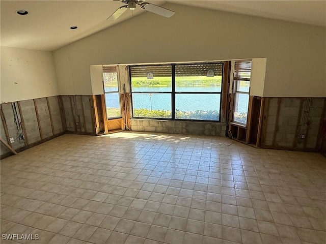 spare room featuring a healthy amount of sunlight, a water view, a ceiling fan, and vaulted ceiling