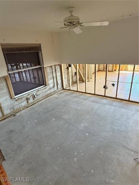 unfurnished living room featuring unfinished concrete flooring and ceiling fan