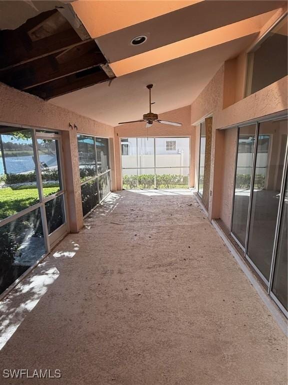 unfurnished sunroom with a ceiling fan